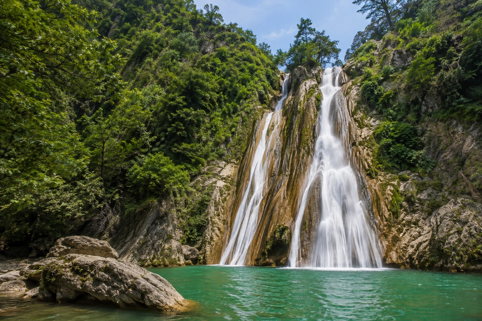 Kempty Falls surrounded by green hills and rocky surroundings